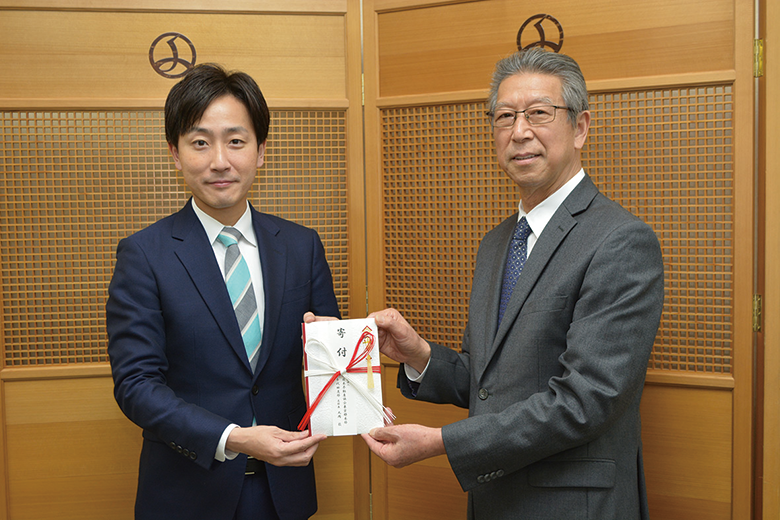 樋口高顕千代田区長（左）に寄付金を贈呈する丸岡支部長